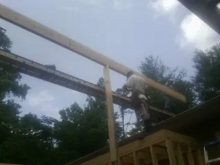 Carpenter setting a ridge beam over a new addition frame — Ice Dam Removal by Roofing Brothers in Manson
