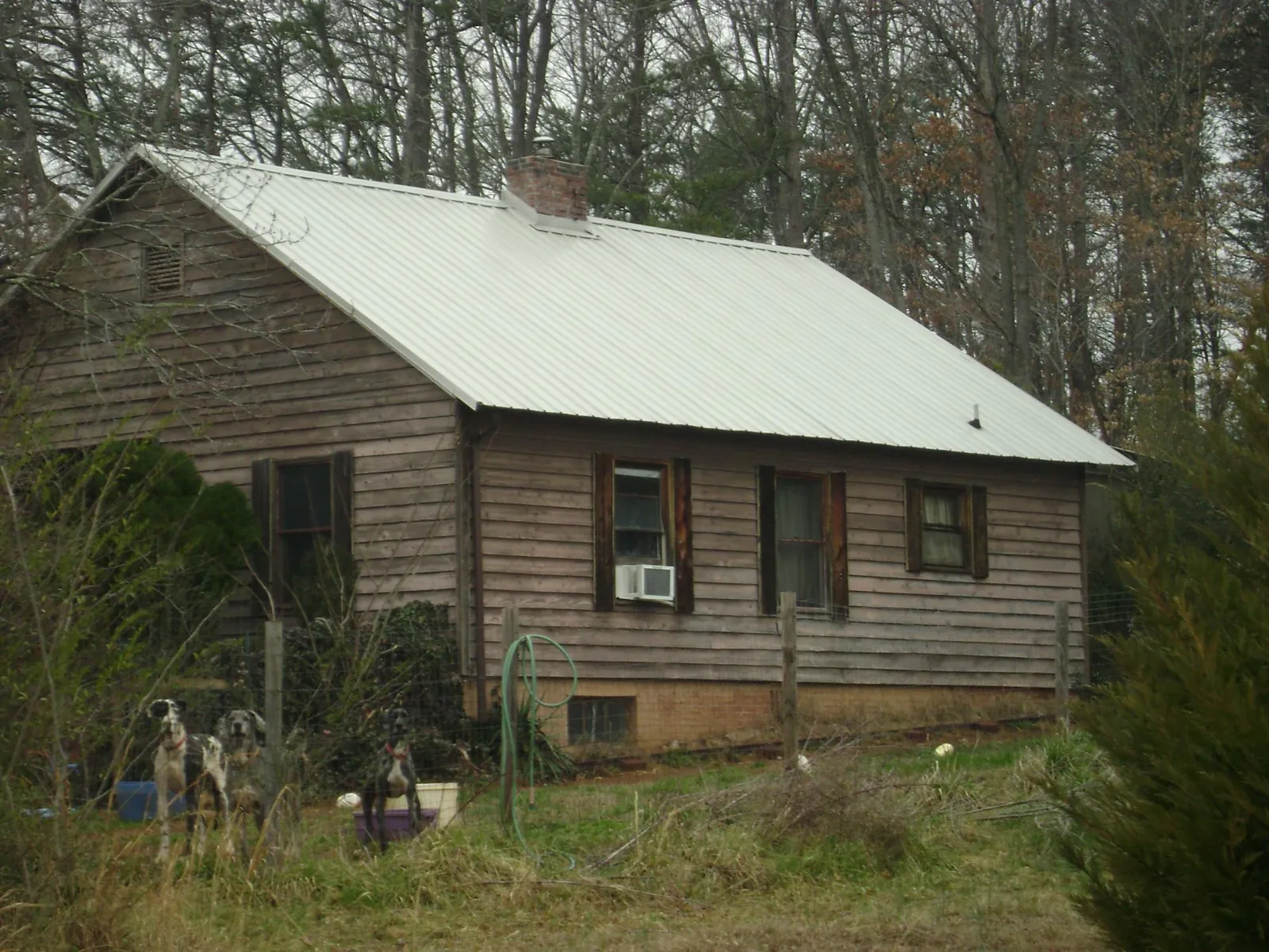 White metal roof on an old wood sided farmhouse, from a Metal Roof Installation job in Manson